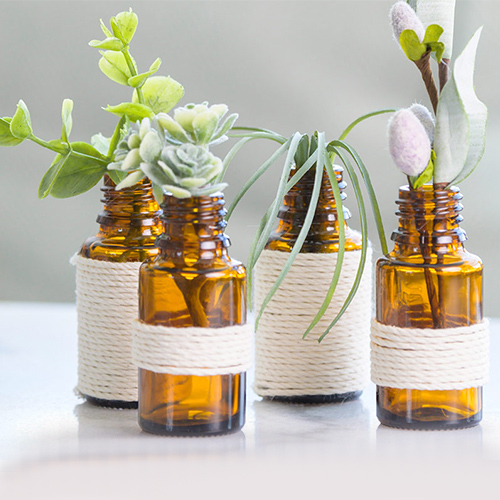 4 bottle of Essential Oils with plants on it