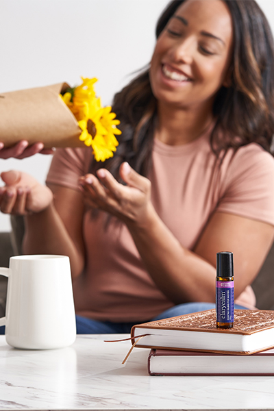 Woman receiving flower clary calm bottle on the table