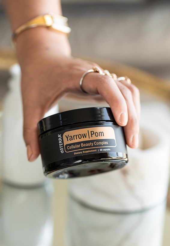 Photo of a hand holidng Yarrow Pom Cellular Beauty Complex Capsules