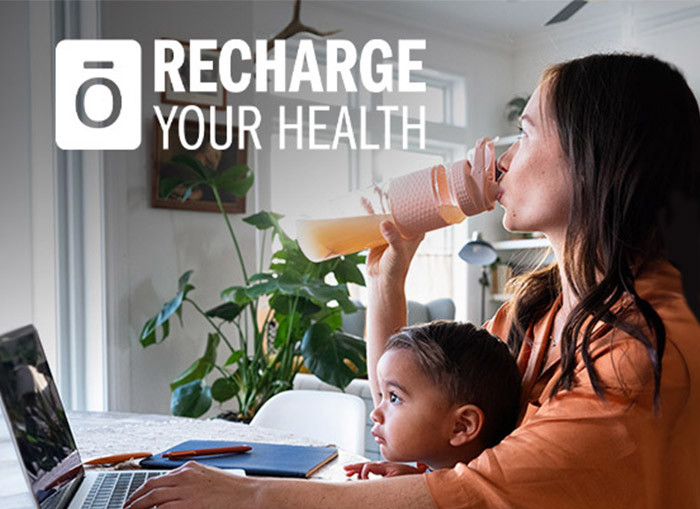 A woman and child sitting at a table with a laptop.
