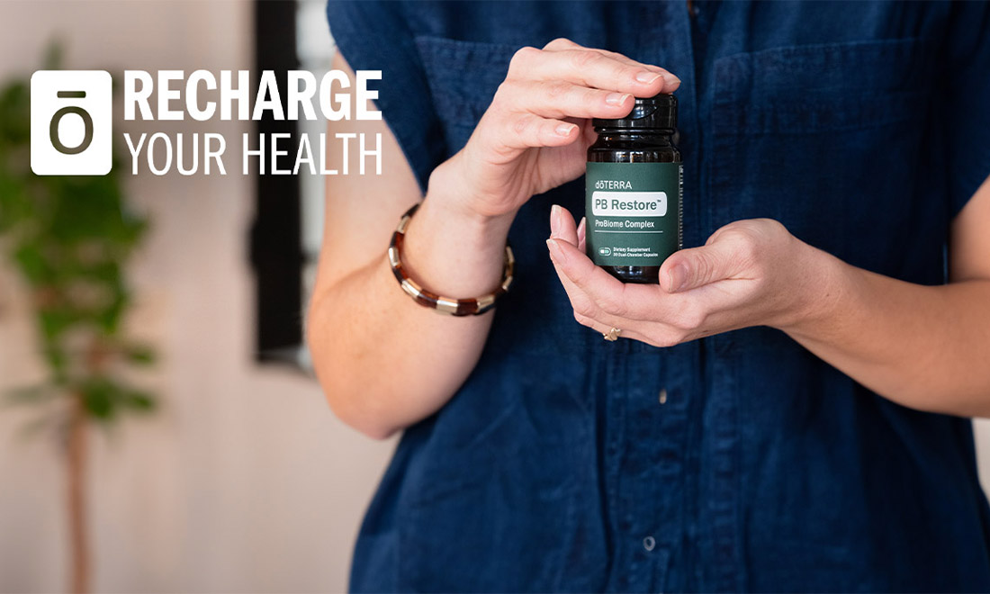 A woman holding a bottle of doTERRA PB Restore.