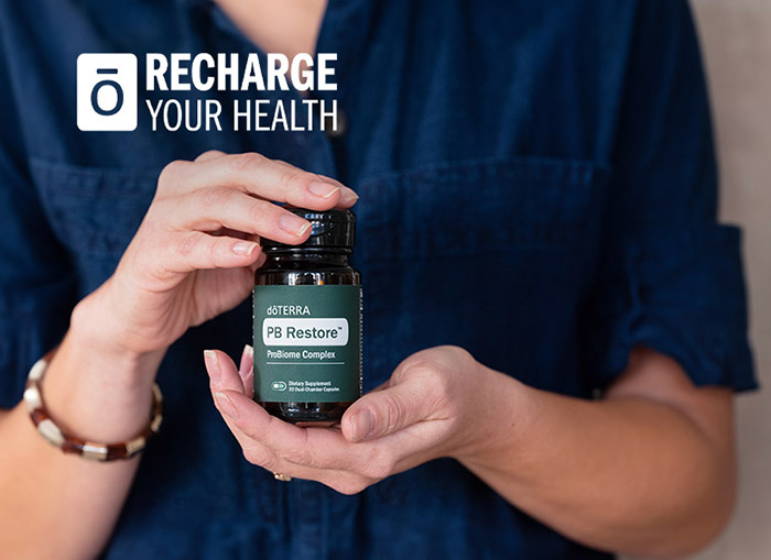 A woman holding a bottle of doTERRA PB Restore.