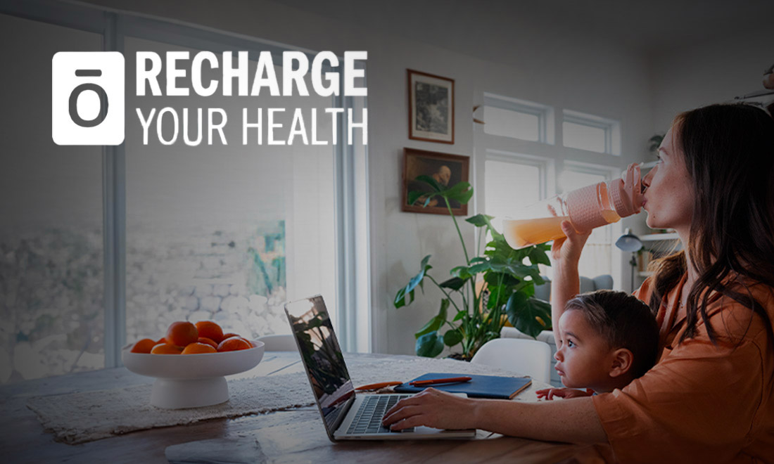 A woman and child sitting at a table with a laptop.