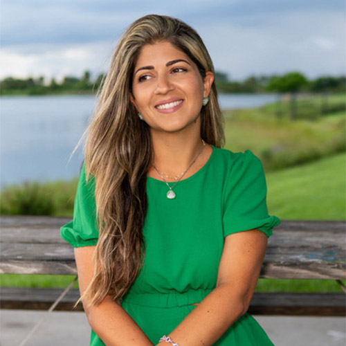 Renata Rivera is sitting on a bench.