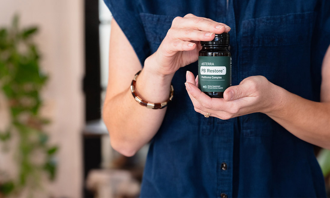 一个女人手握一瓶doTERRA複合益生菌膠囊