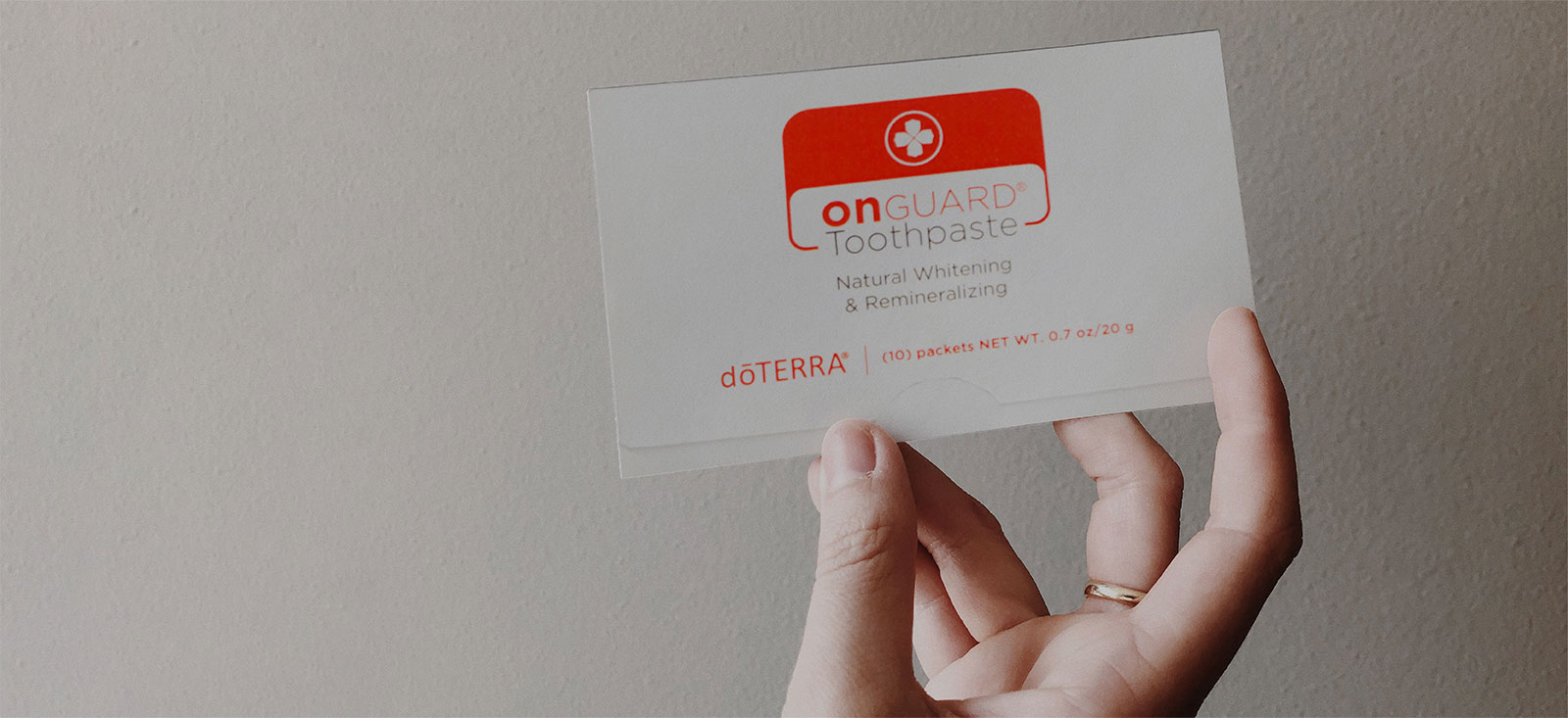 Someone holding On Guard Toothpaste Sample