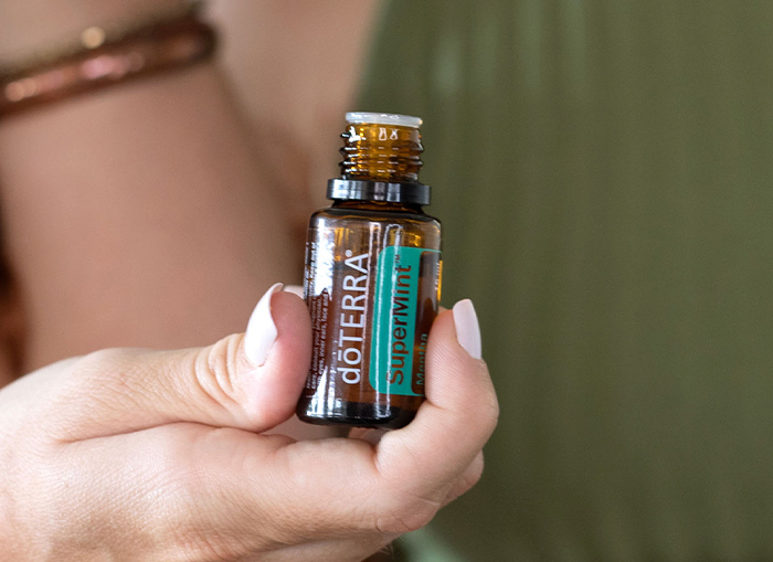 Woman holding SuperMint Essential Oil