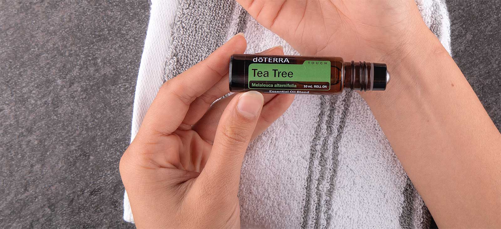 Hand holding Tea Tree Touch over their wrist