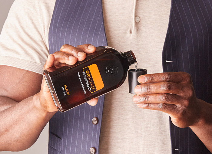 Man dropping doTERRA Mouthwash in a cup