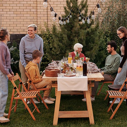 Family sitting around a table outside enjoying summer